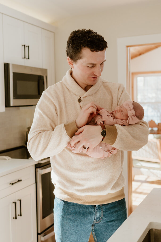 dad holding newborn in kitchen