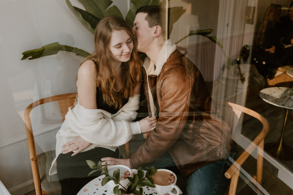 Affectionate young couple sharing a tender moment at Elixxr Cafe in Beacon, NY, showcasing the cafe's cozy and romantic atmosphere perfect for a photoshoot.