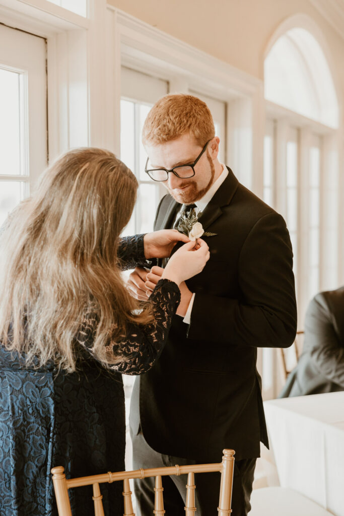 Groom getting ready in a stylish suit at The Links at Union Vale wedding venue.