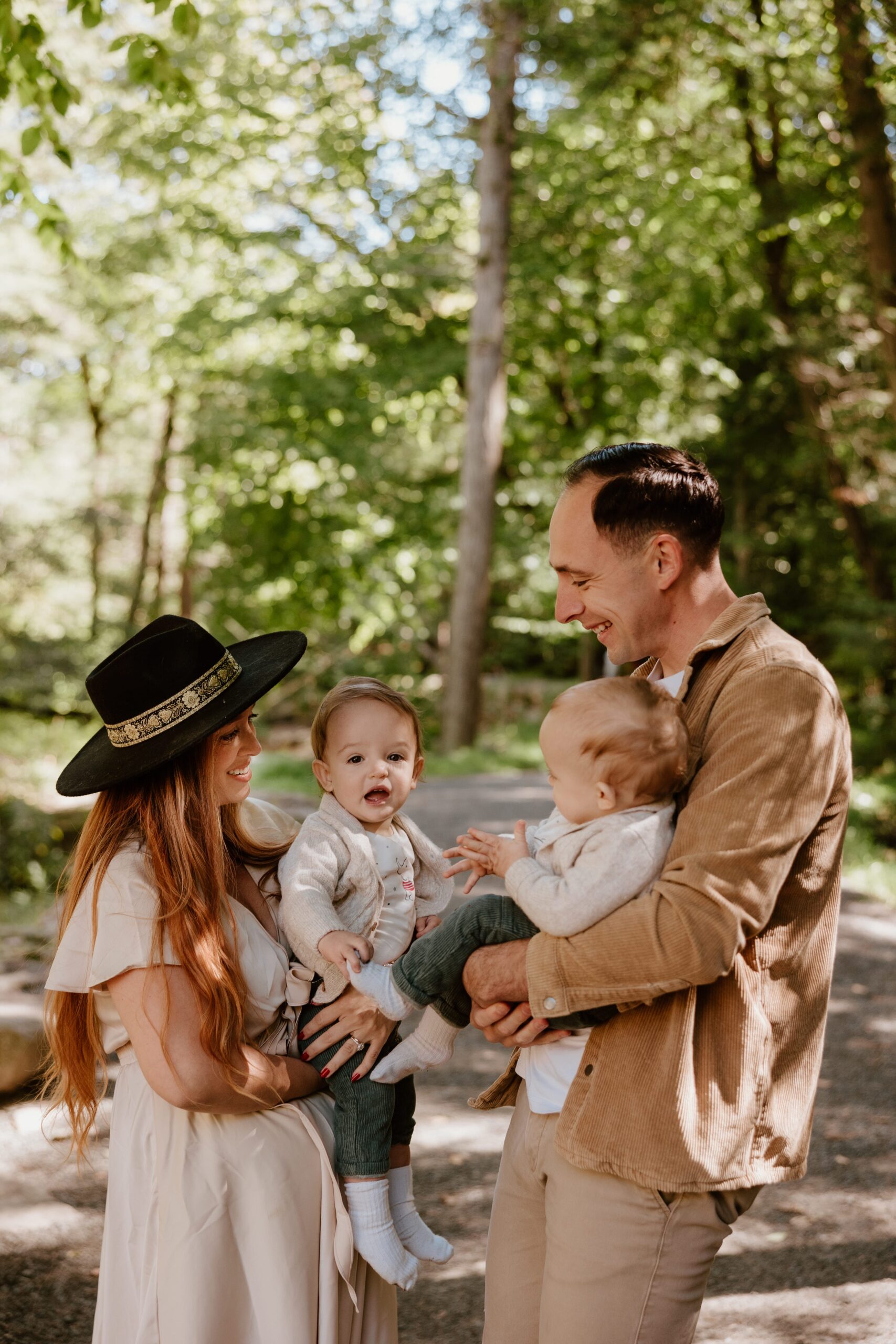 Happy family enjoying a playful moment in a lush Hudson Valley forest during a photography session with Little Cacti Photography.