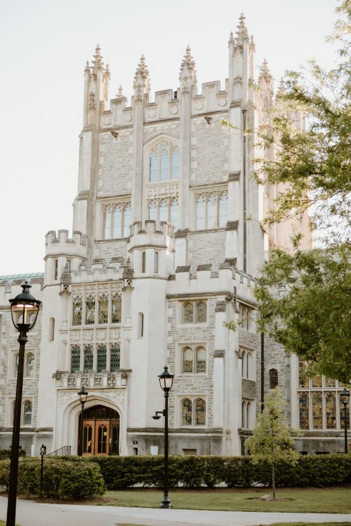 Exterior view of the Thompson Memorial Library at Vassar College in Poughkeepsie, NY, captured during golden hour with surrounding greenery and gothic architecture details.