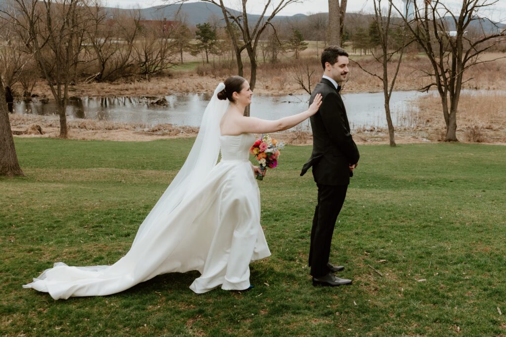 Bride tapping groom on shoulder during first look