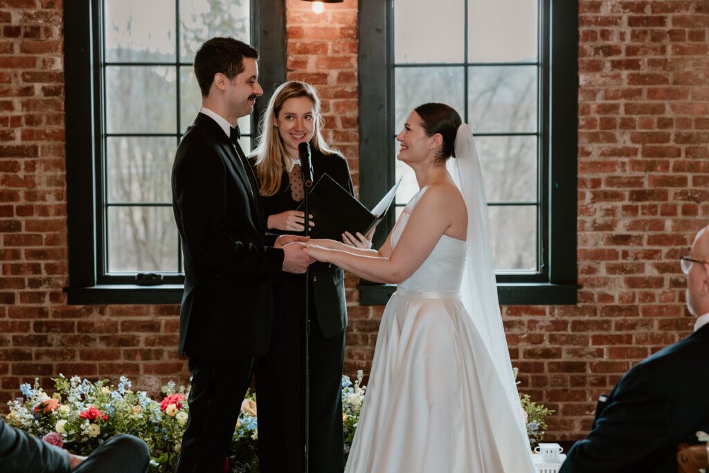 Bride and groom holding hands during their wedding ceremony at Drowned Lands Brewery