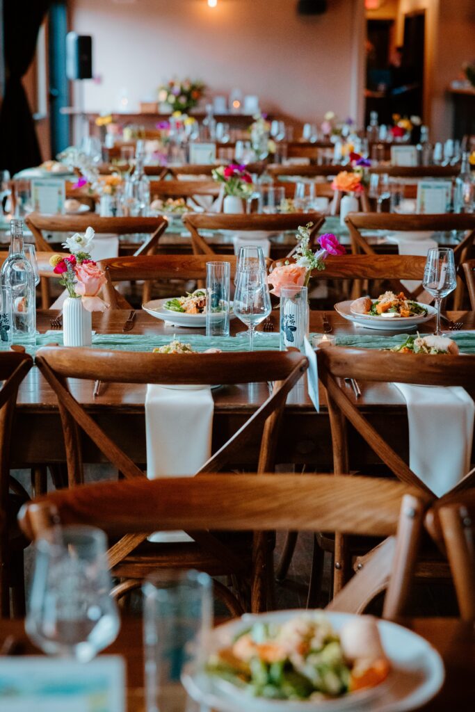 Wedding reception table setup at Drowned Lands Brewery in Warwick NY with wood tables, floral centerpieces, and intimate dining details