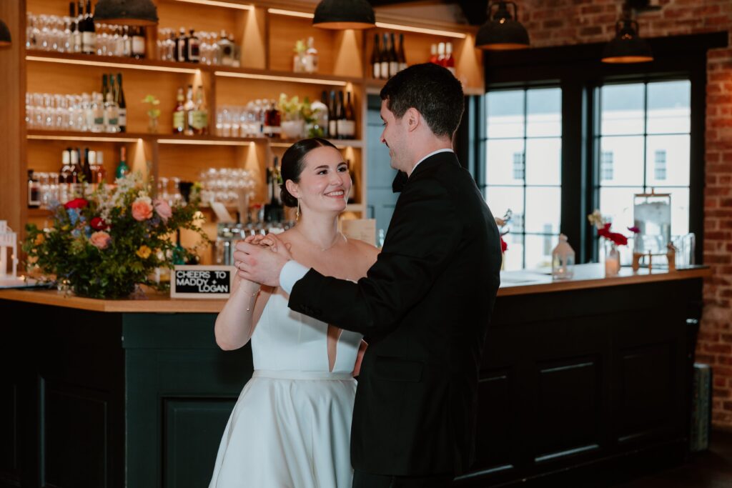 Bride and groom sharing their first dance at Drowned Lands Brewery in Warwick NY with warm bar lighting and intimate reception atmosphere